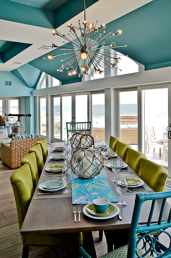 На фото: огромная гостиная-столовая в морском стиле с синими стенами и светлым паркетным полом с
