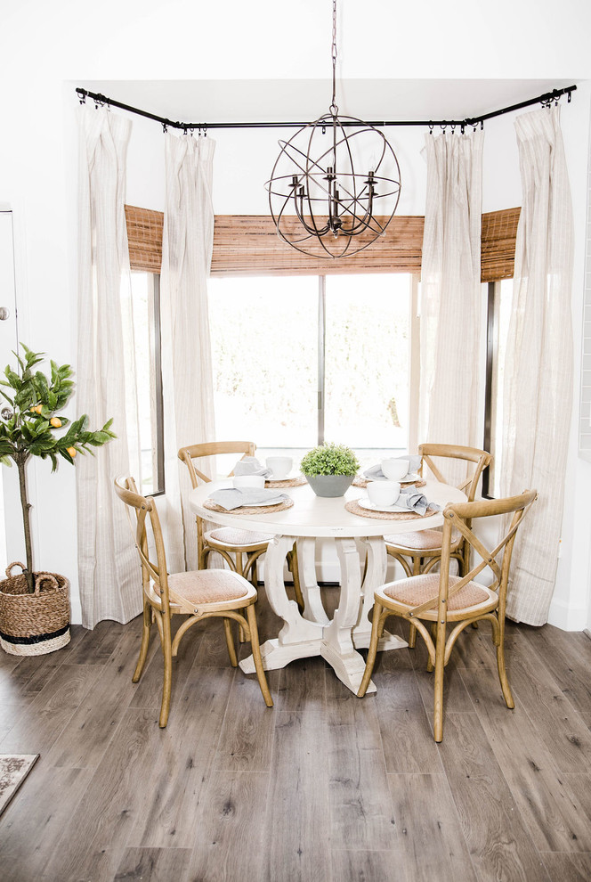 Esempio di una sala da pranzo aperta verso la cucina stile marino di medie dimensioni con pareti bianche, pavimento in laminato e pavimento grigio