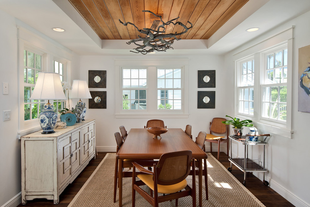 Photo of a beach style enclosed dining room in Miami with white walls, dark hardwood flooring and feature lighting.