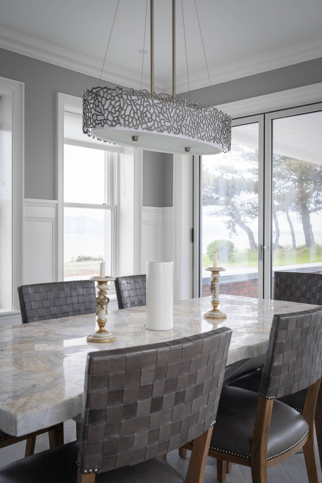 This is an example of a coastal dining room in Other with porcelain flooring and grey floors.