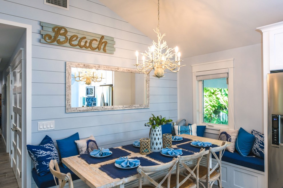 タンパにある高級なビーチスタイルのおしゃれなダイニングキッチン (青い壁、磁器タイルの床、グレーの床) の写真