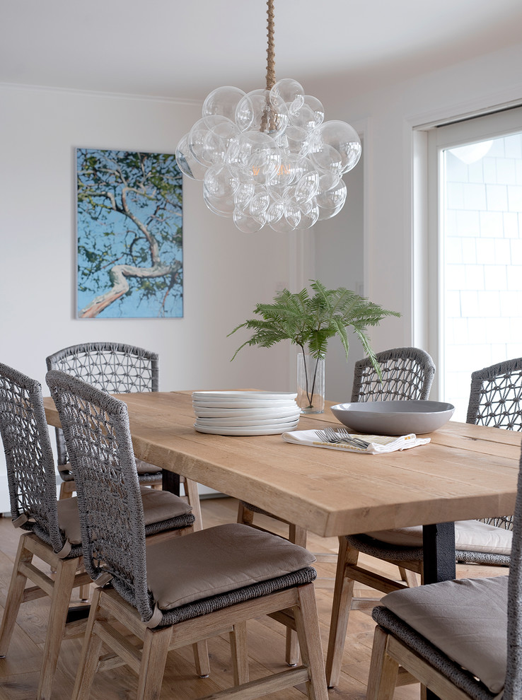 Foto di una sala da pranzo stile marinaro con pareti bianche, pavimento in legno massello medio e pavimento marrone