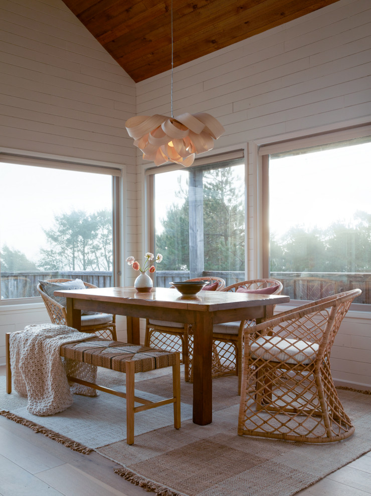 Example of a mid-sized beach style light wood floor, beige floor, wood ceiling, vaulted ceiling and shiplap wall dining room design in Other with white walls