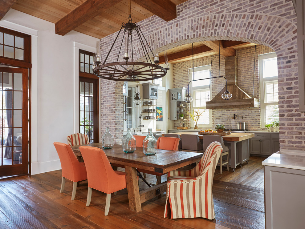 Foto di una sala da pranzo aperta verso la cucina stile marinaro con pareti bianche, pavimento in legno massello medio e pavimento marrone