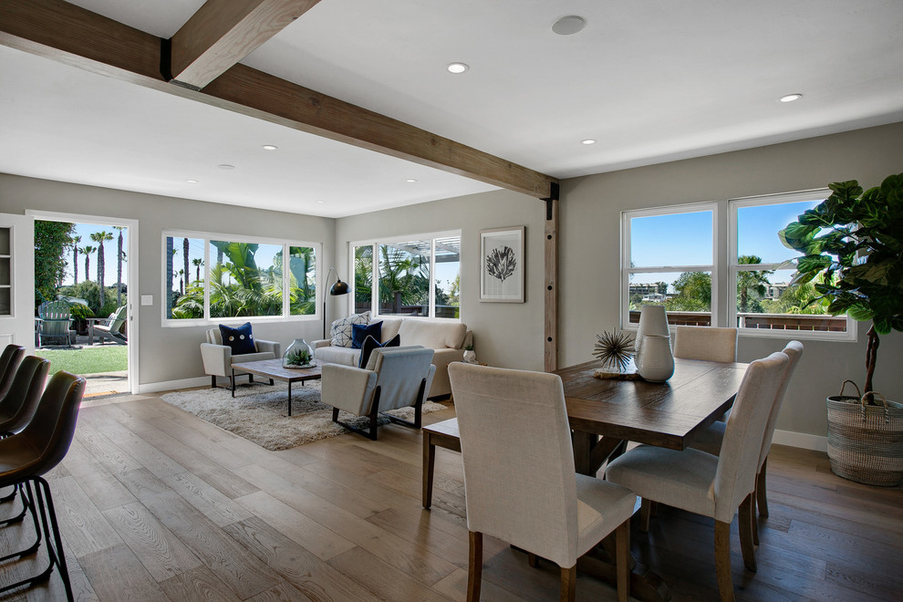 Idee per una sala da pranzo aperta verso il soggiorno stile marinaro di medie dimensioni con pareti grigie, pavimento in legno massello medio e pavimento beige