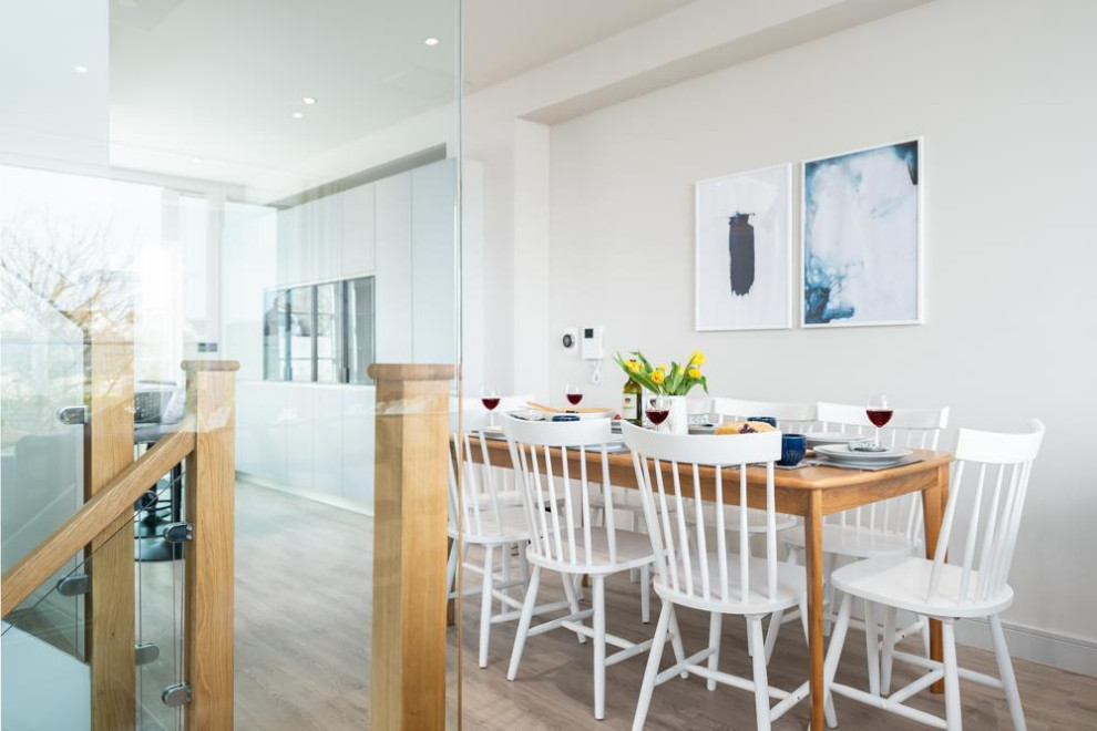 Cette image montre une salle à manger ouverte sur le salon marine de taille moyenne avec un mur gris et parquet clair.