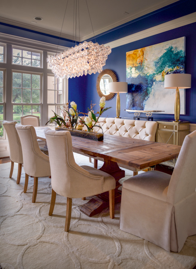 Cette photo montre une grande salle à manger ouverte sur le salon chic avec un mur bleu, un sol en bois brun, un sol marron et éclairage.