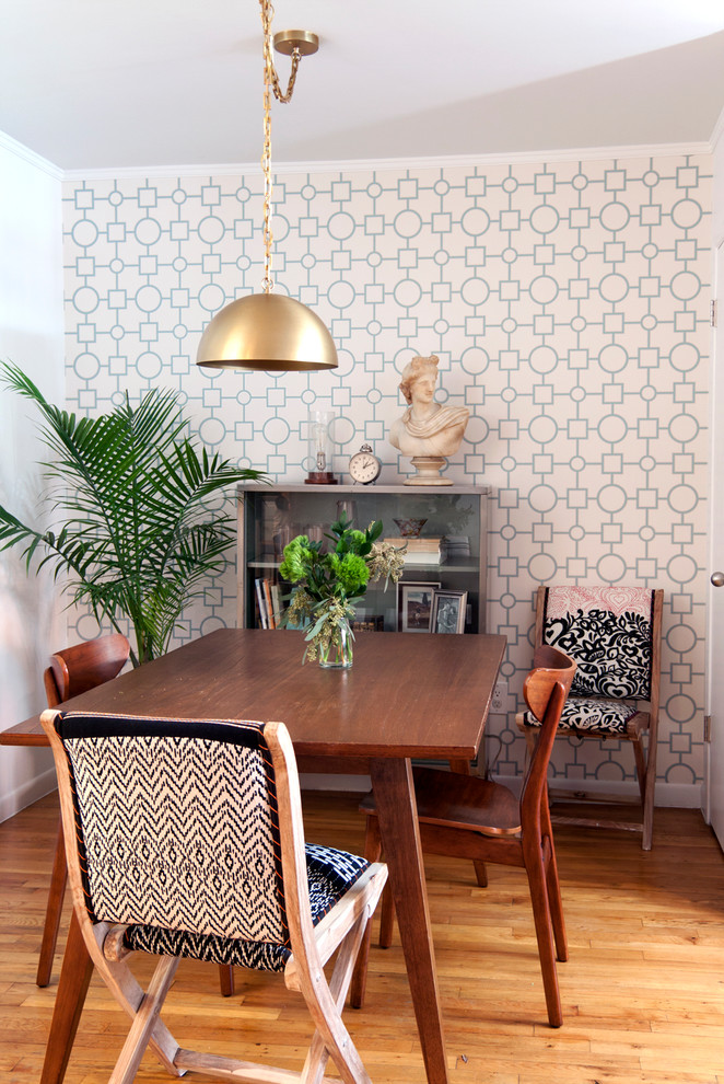 Immagine di una sala da pranzo boho chic con pareti bianche, pavimento in legno massello medio e pavimento marrone