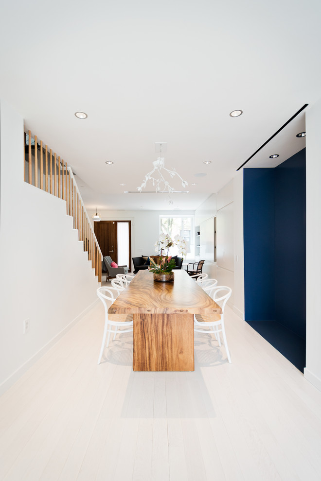 Cette image montre une salle à manger design avec un mur bleu et un sol blanc.
