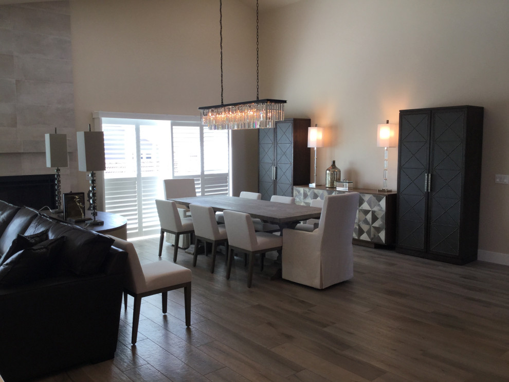 На фото: большая гостиная-столовая в стиле модернизм с серыми стенами, паркетным полом среднего тона, стандартным камином, фасадом камина из плитки и коричневым полом с