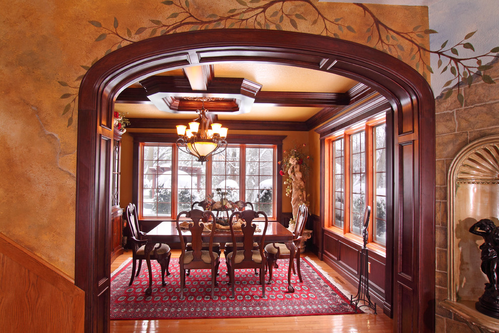 Cette image montre une grande salle à manger traditionnelle fermée avec un mur multicolore et un sol en bois brun.