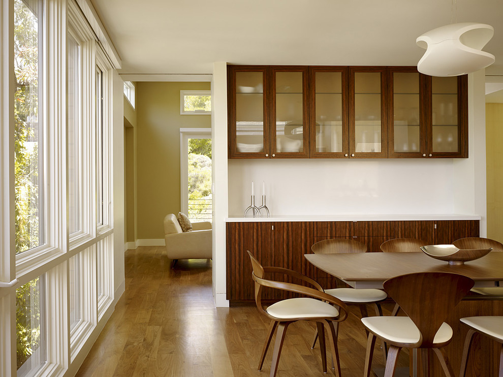 Пример оригинального дизайна: столовая в стиле модернизм с белыми стенами и паркетным полом среднего тона