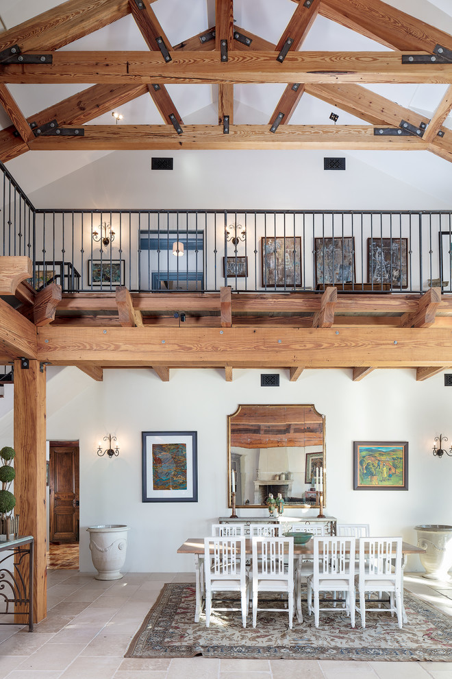 На фото: большая гостиная-столовая в средиземноморском стиле с белыми стенами и бетонным полом без камина