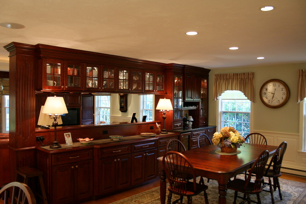 Aménagement d'une grande salle à manger ouverte sur la cuisine classique avec un mur blanc et un sol en bois brun.
