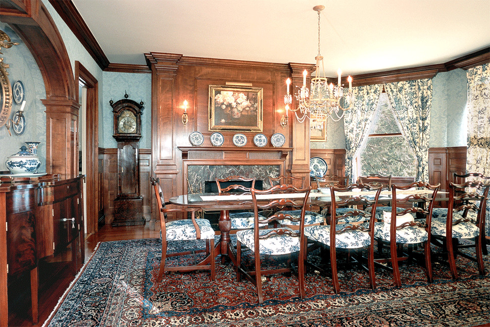 Пример оригинального дизайна: большая отдельная столовая в классическом стиле с синими стенами, паркетным полом среднего тона, стандартным камином и фасадом камина из камня