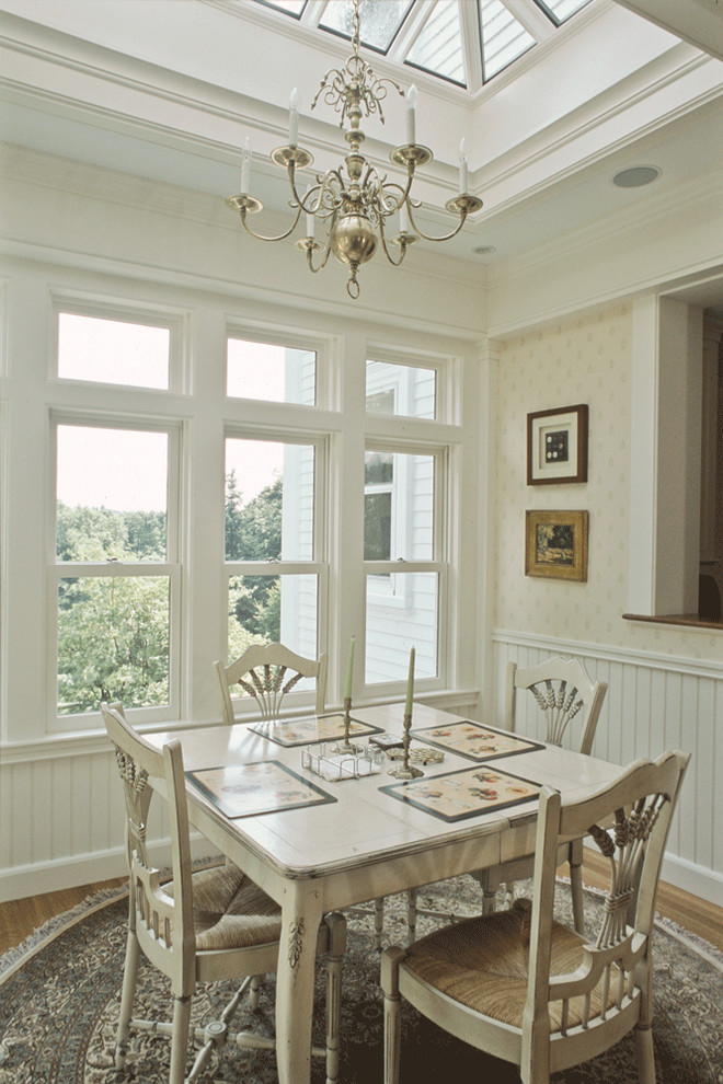 Immagine di una sala da pranzo aperta verso la cucina tradizionale di medie dimensioni con pavimento in legno massello medio e pareti gialle