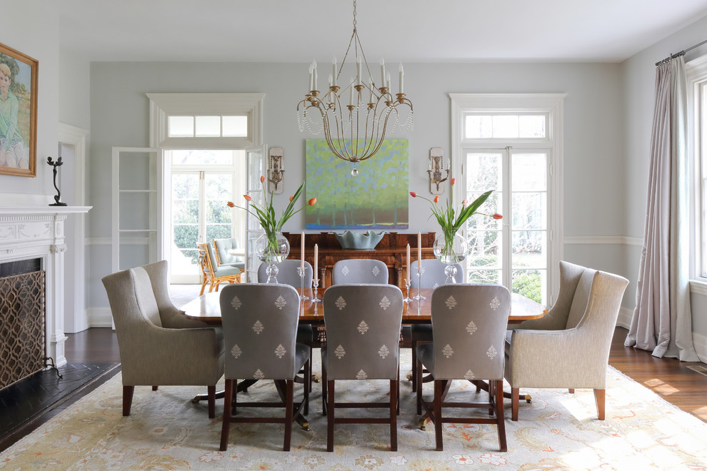 Стильный дизайн: столовая в классическом стиле с синими стенами, паркетным полом среднего тона, стандартным камином и коричневым полом - последний тренд