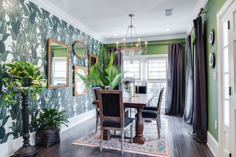 Immagine di una grande sala da pranzo aperta verso la cucina tropicale con pareti verdi, parquet scuro, nessun camino e pavimento marrone