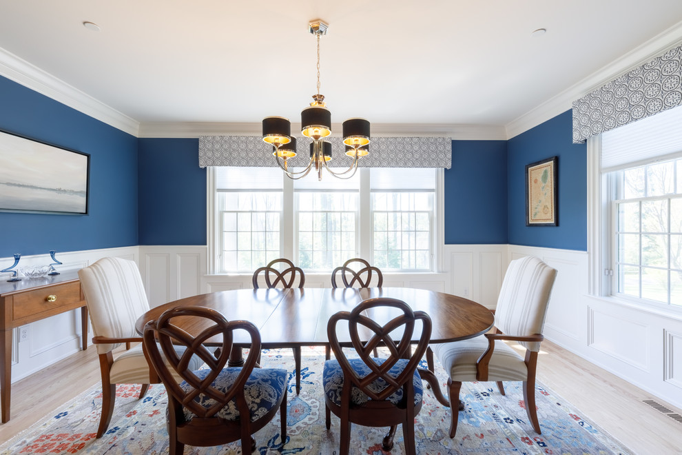 Imagen de comedor clásico grande cerrado con suelo de madera clara y paredes azules