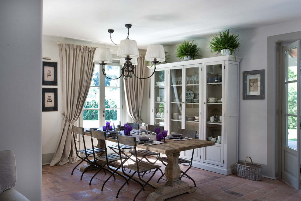 Inspiration for a shabby-chic style brick floor dining room remodel in Florence with white walls