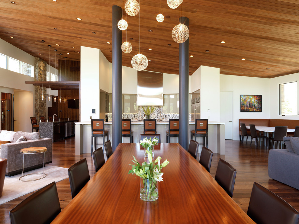 Foto di una sala da pranzo aperta verso il soggiorno moderna con pareti bianche e pavimento in legno massello medio