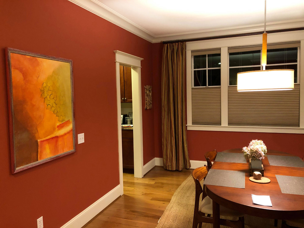Idée de décoration pour une salle à manger craftsman fermée et de taille moyenne avec un mur orange, un sol en bois brun et un sol marron.