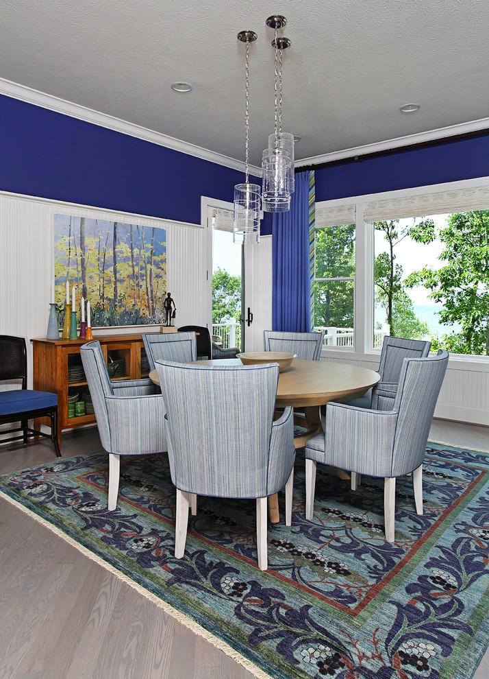 Diseño de comedor tradicional de tamaño medio abierto sin chimenea con paredes azules, suelo de madera en tonos medios, suelo gris y cortinas