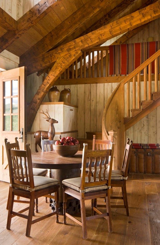 Esempio di una sala da pranzo rustica con pavimento in legno massello medio