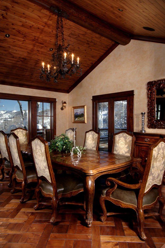 Example of a large mountain style dark wood floor enclosed dining room design in Denver with beige walls and no fireplace