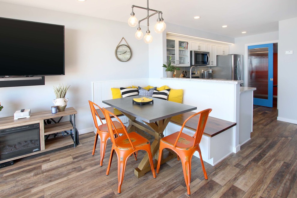Immagine di una sala da pranzo aperta verso la cucina costiera di medie dimensioni con pareti bianche, pavimento marrone, parquet scuro e nessun camino