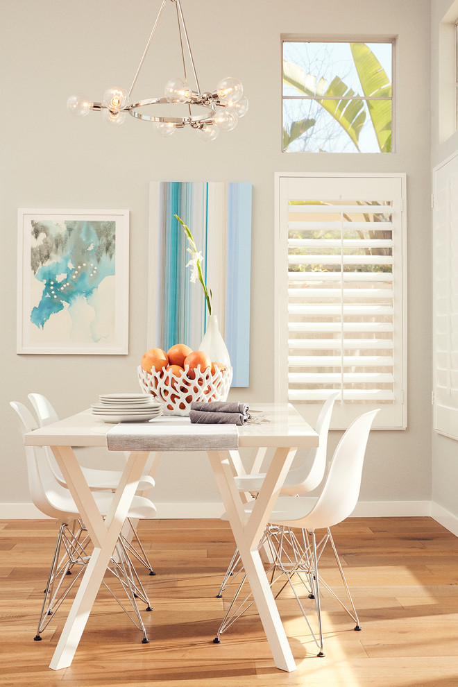 This is an example of a coastal dining room in Los Angeles with grey walls, light hardwood flooring and brown floors.