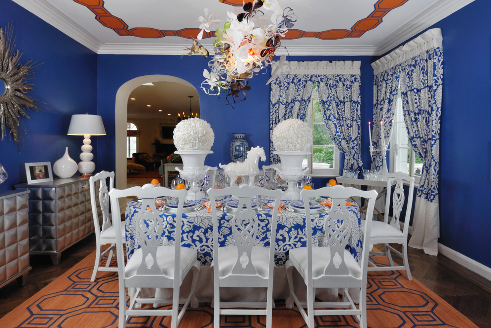 Exemple d'une salle à manger éclectique fermée et de taille moyenne avec un mur bleu, parquet foncé et éclairage.
