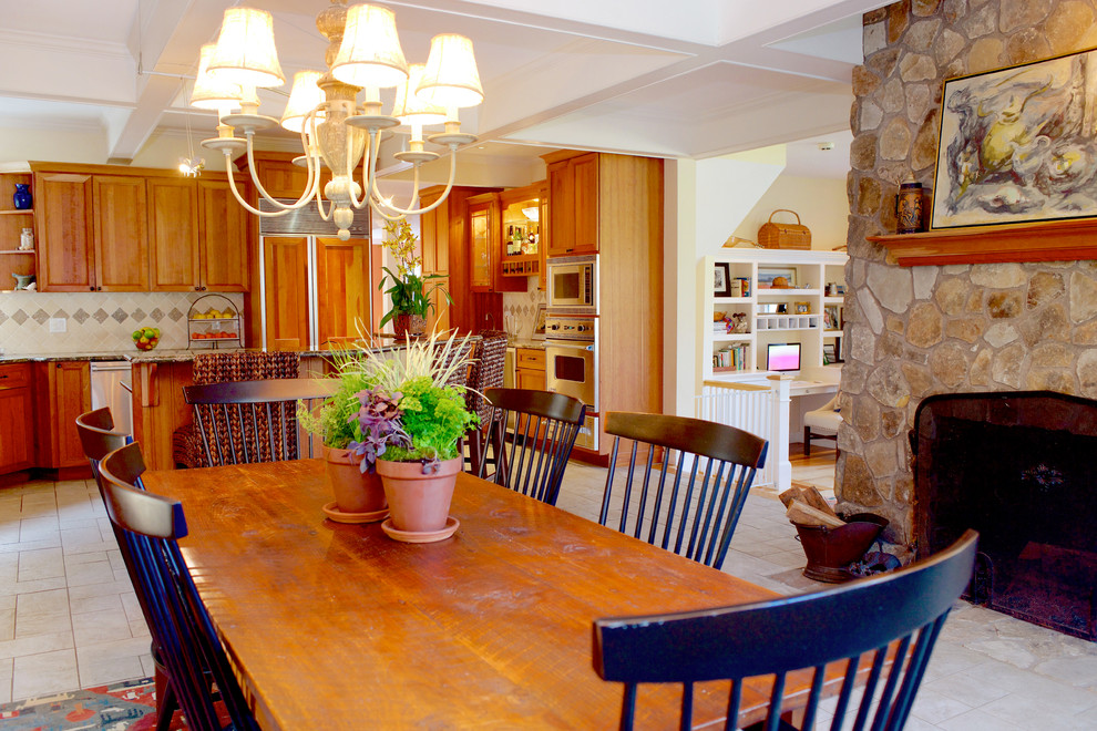 This is an example of a medium sized rustic kitchen/dining room in Boston with concrete flooring, white walls, a standard fireplace, a stone fireplace surround and beige floors.