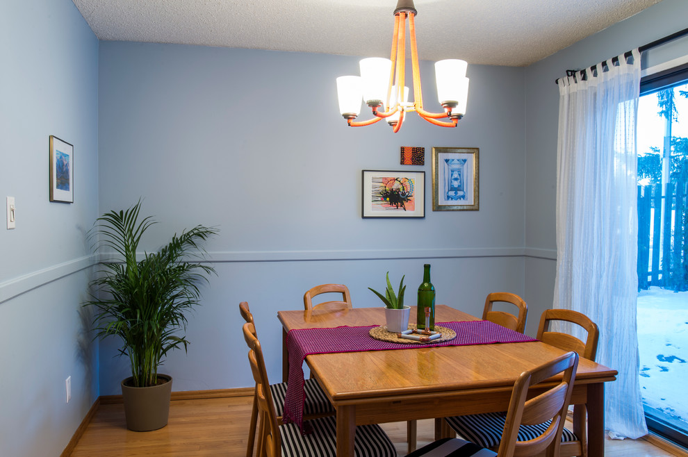 Idées déco pour une salle à manger ouverte sur la cuisine rétro de taille moyenne avec un mur bleu, parquet clair et aucune cheminée.