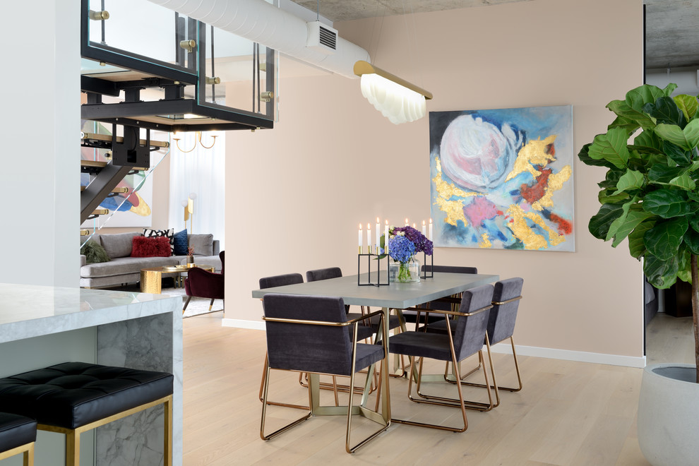 Idée de décoration pour une salle à manger ouverte sur le salon minimaliste de taille moyenne avec un mur rose, parquet clair, aucune cheminée et un sol beige.