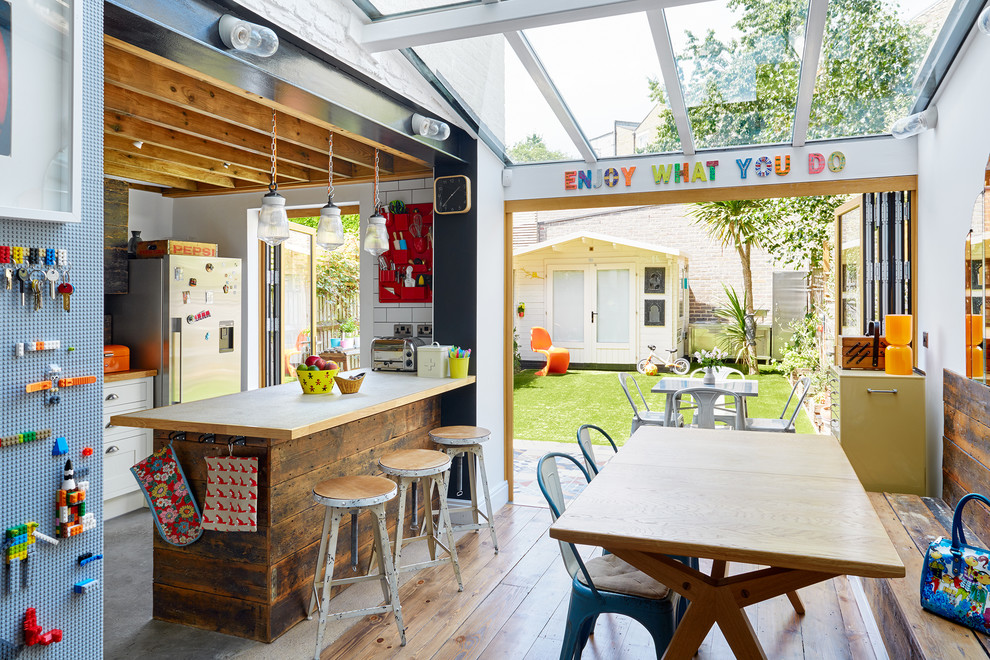 Mittelgroße Eklektische Wohnküche mit braunem Holzboden in London