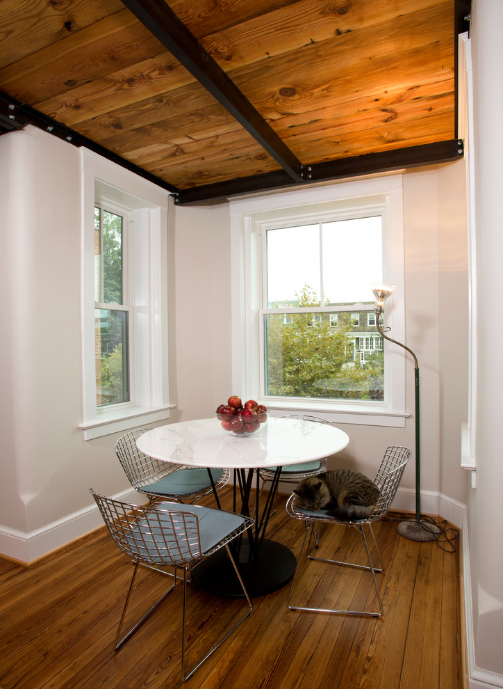 Foto di una piccola sala da pranzo design con pavimento in legno massello medio, nessun camino e pareti grigie
