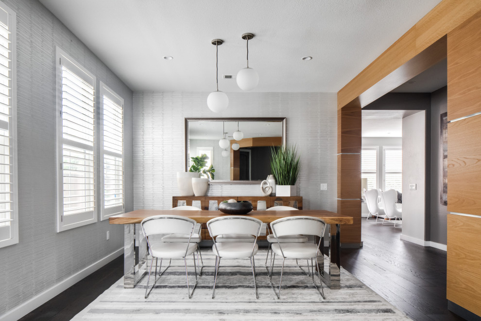 Offenes, Mittelgroßes Modernes Esszimmer mit grauer Wandfarbe, dunklem Holzboden, braunem Boden, freigelegten Dachbalken und Tapetenwänden in Orange County