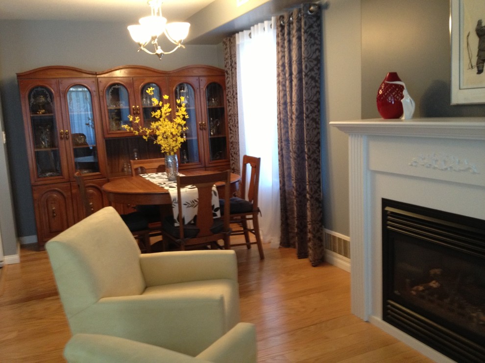 Example of a small transitional light wood floor kitchen/dining room combo design in Other with gray walls, a standard fireplace and a wood fireplace surround