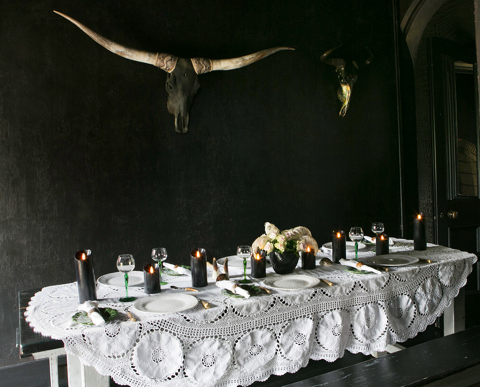 Exemple d'une salle à manger éclectique fermée avec un mur noir.