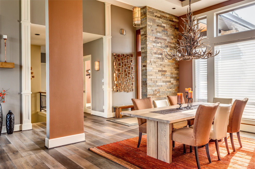 На фото: большая гостиная-столовая в стиле модернизм с оранжевыми стенами, темным паркетным полом и коричневым полом без камина с