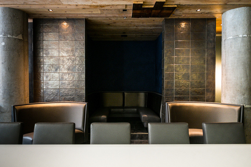 Idée de décoration pour une grande salle à manger ouverte sur la cuisine urbaine avec un mur gris et un sol noir.