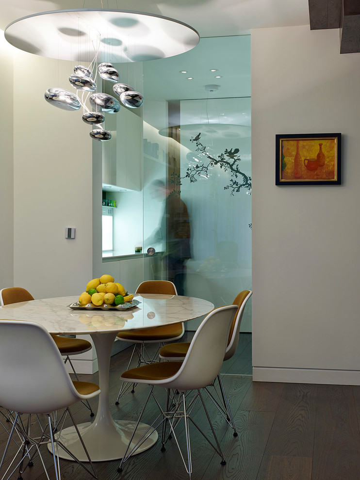 Small contemporary open plan dining room in London with white walls and dark hardwood flooring.