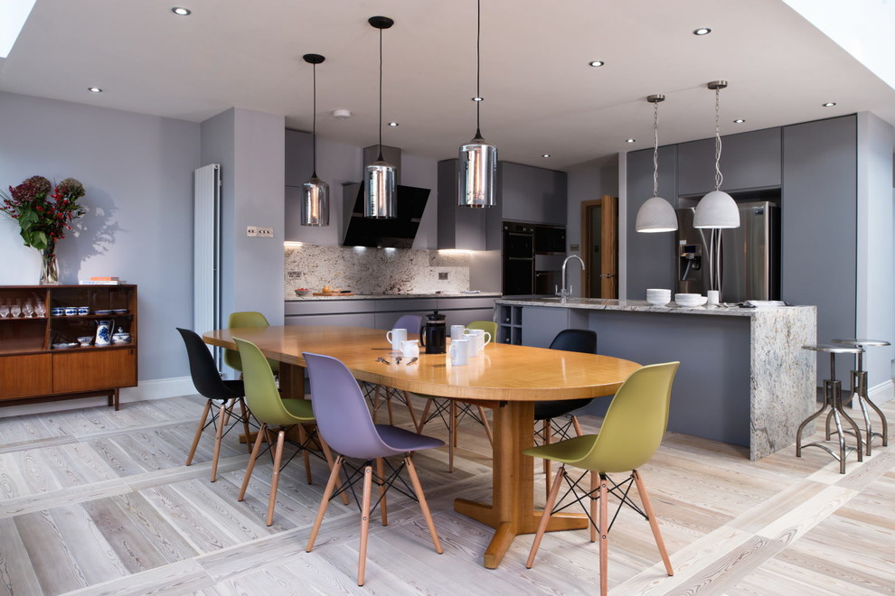Idée de décoration pour une salle à manger ouverte sur la cuisine design avec un mur gris et parquet clair.