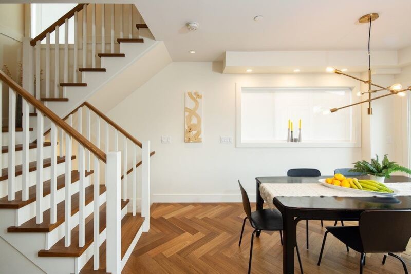 Exemple d'une salle à manger ouverte sur le salon chic de taille moyenne avec un mur blanc, aucune cheminée, un sol marron et un sol en vinyl.
