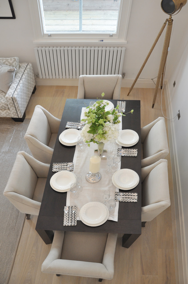 Medium sized traditional open plan dining room in London with white walls, medium hardwood flooring and no fireplace.