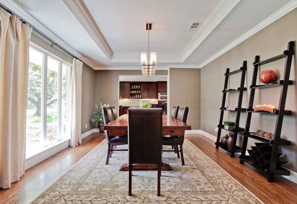 This is an example of a large traditional enclosed dining room in New York with beige walls, dark hardwood flooring, no fireplace and brown floors.