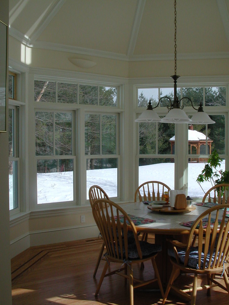 Immagine di una sala da pranzo aperta verso la cucina country di medie dimensioni con pareti gialle e parquet chiaro