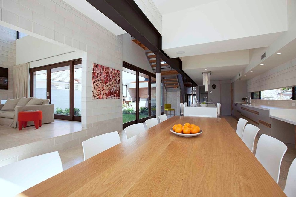 Aménagement d'une très grande salle à manger ouverte sur la cuisine contemporaine avec un mur gris et un sol en travertin.