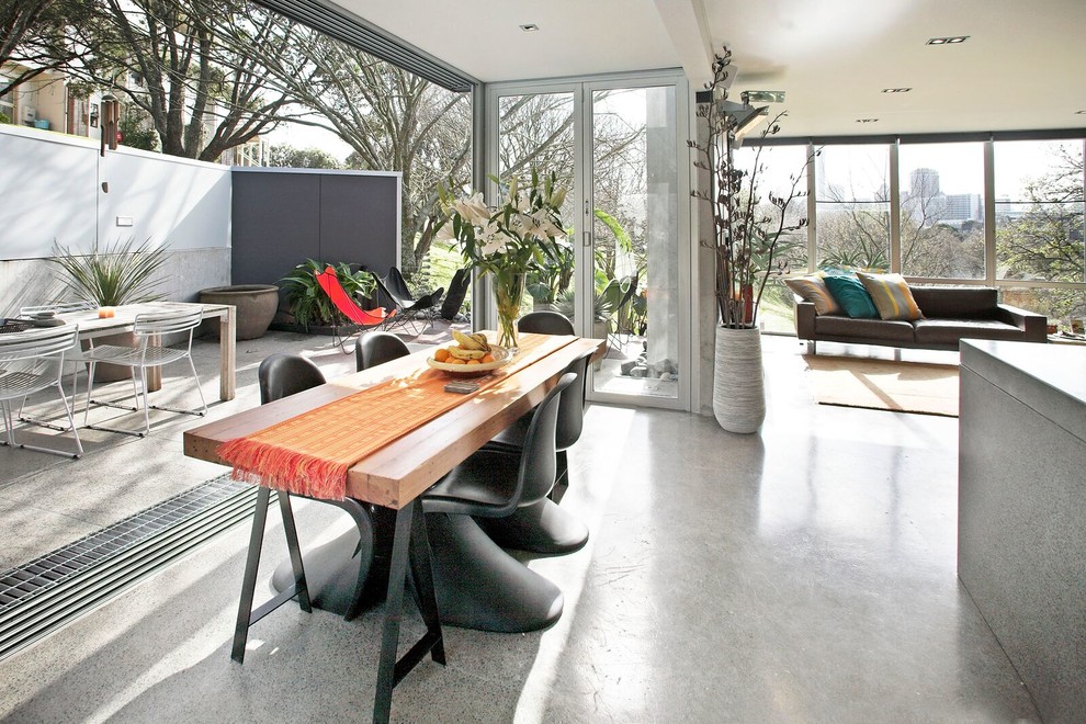 Idee per una sala da pranzo aperta verso il soggiorno design con pavimento in cemento